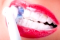 weiße Zähne werden mit einer elektrischen Zahnbürste geputzt